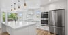 A kitchen remodel with a large island, stainless appliances, and white cabinetry by Marshall Homes in Salt Lake City