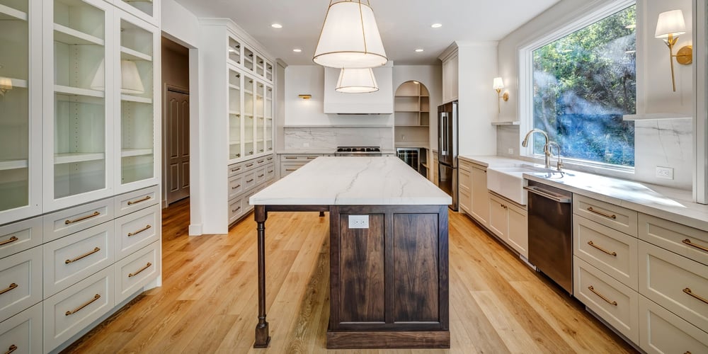 Custom Remodeled kitchen with white cabinetry and wood features with large window in Utah