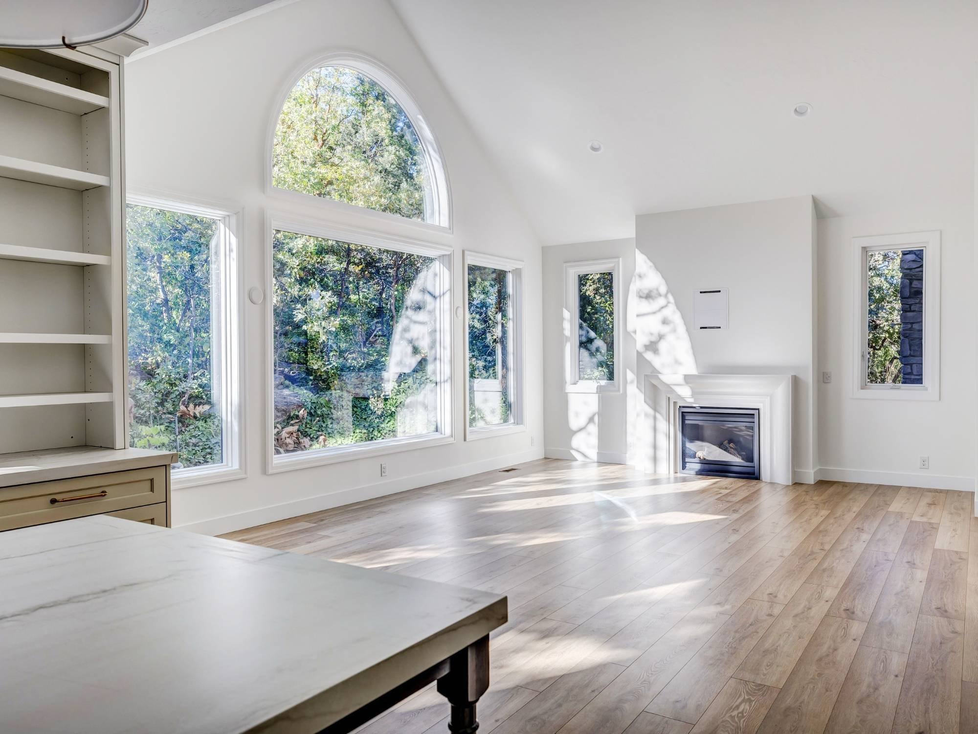 A remodeled great room with large windows, fireplace, and natural light in Olympus Cove, UT by Marshall Homes