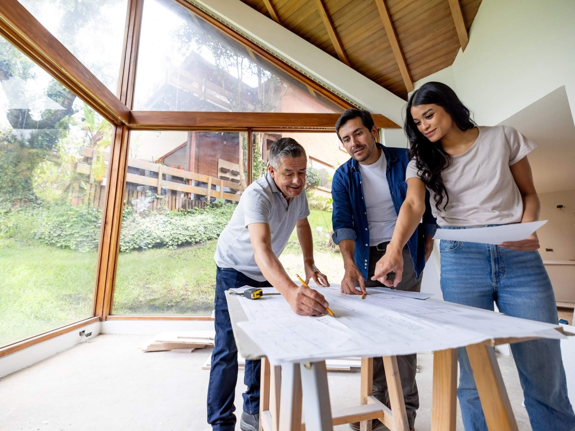 An architect working on a remodeling plan with a young couple inside their partially finished home in Salt Lake City, Utah
