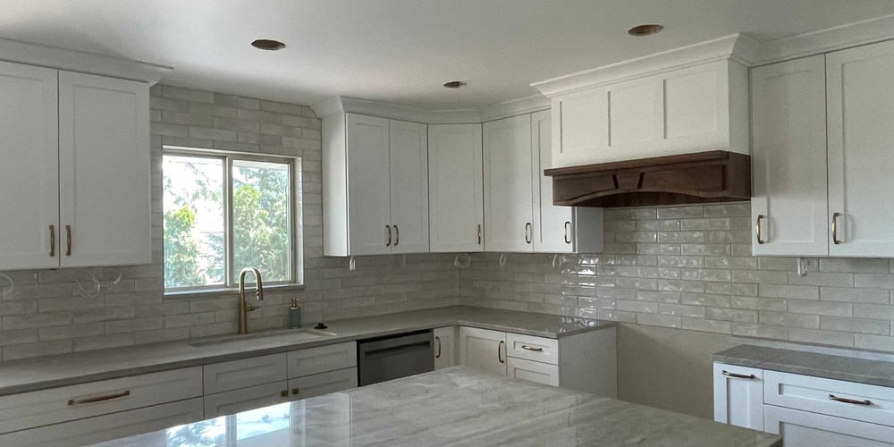 Image of a bright kitchen renovation with white counters and cabinets by Marshall Homes Utah