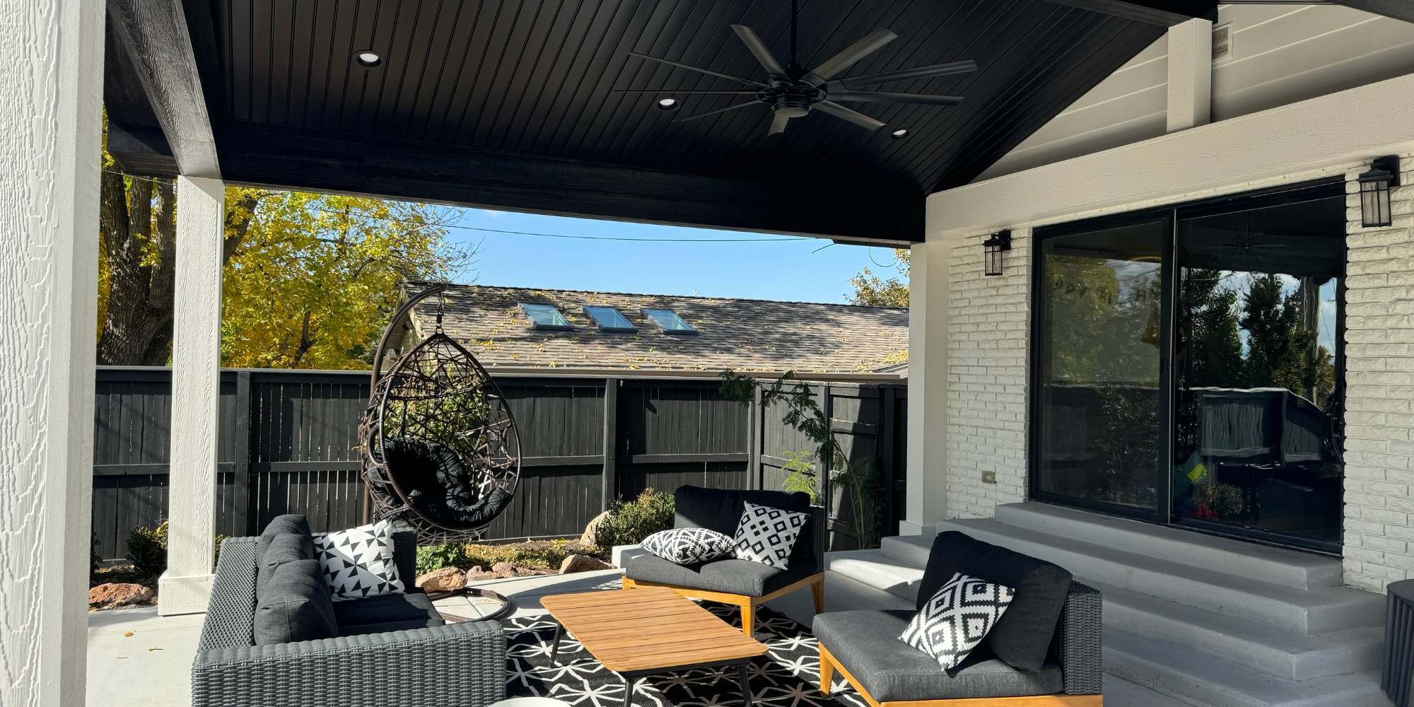 Custom backyard living space addition in Salt Lake City featuring a hanging chair and lounge area.