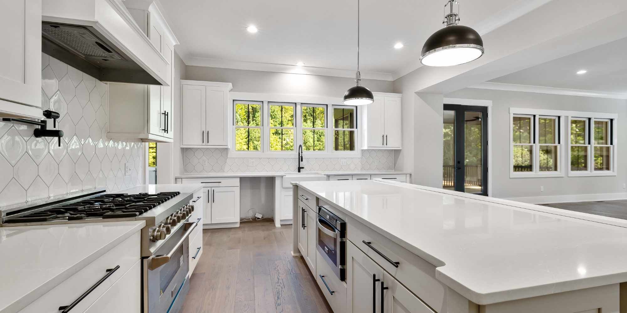 Luxury kitchen remodel in Utah featuring large island, pendant lights, and bright finishes