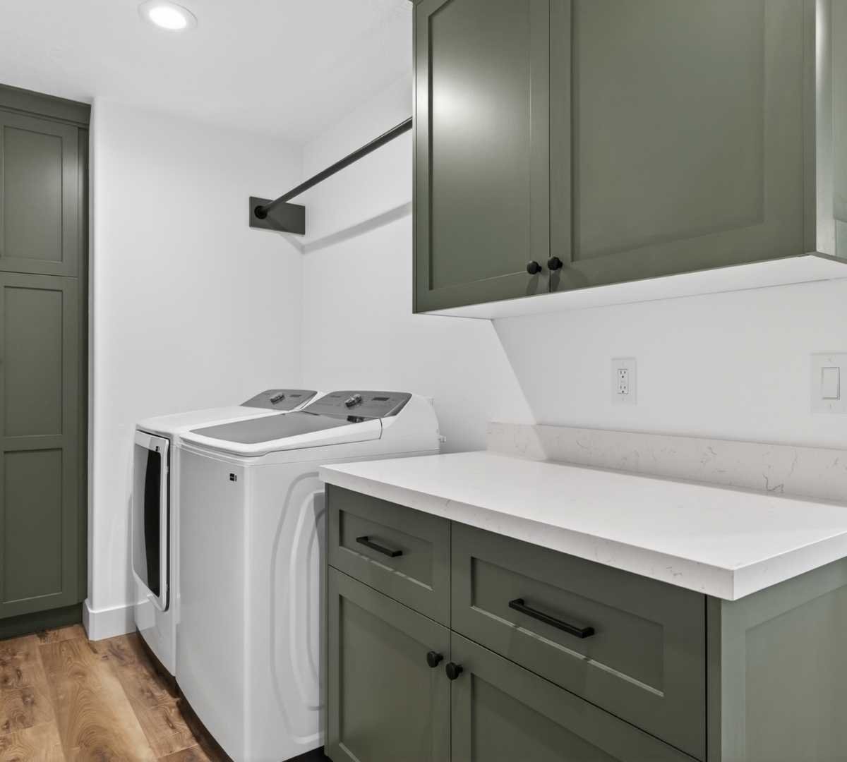 Image of custom laundry room remodel with green cabinetry and folding counter by Marshall Homes in Herriman, UT