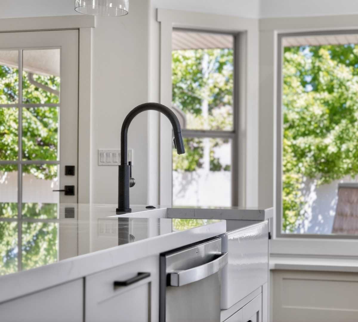 Photo of kitchen island with farmhouse sink and oversized windows by Marshall Homes in Herriman, UT