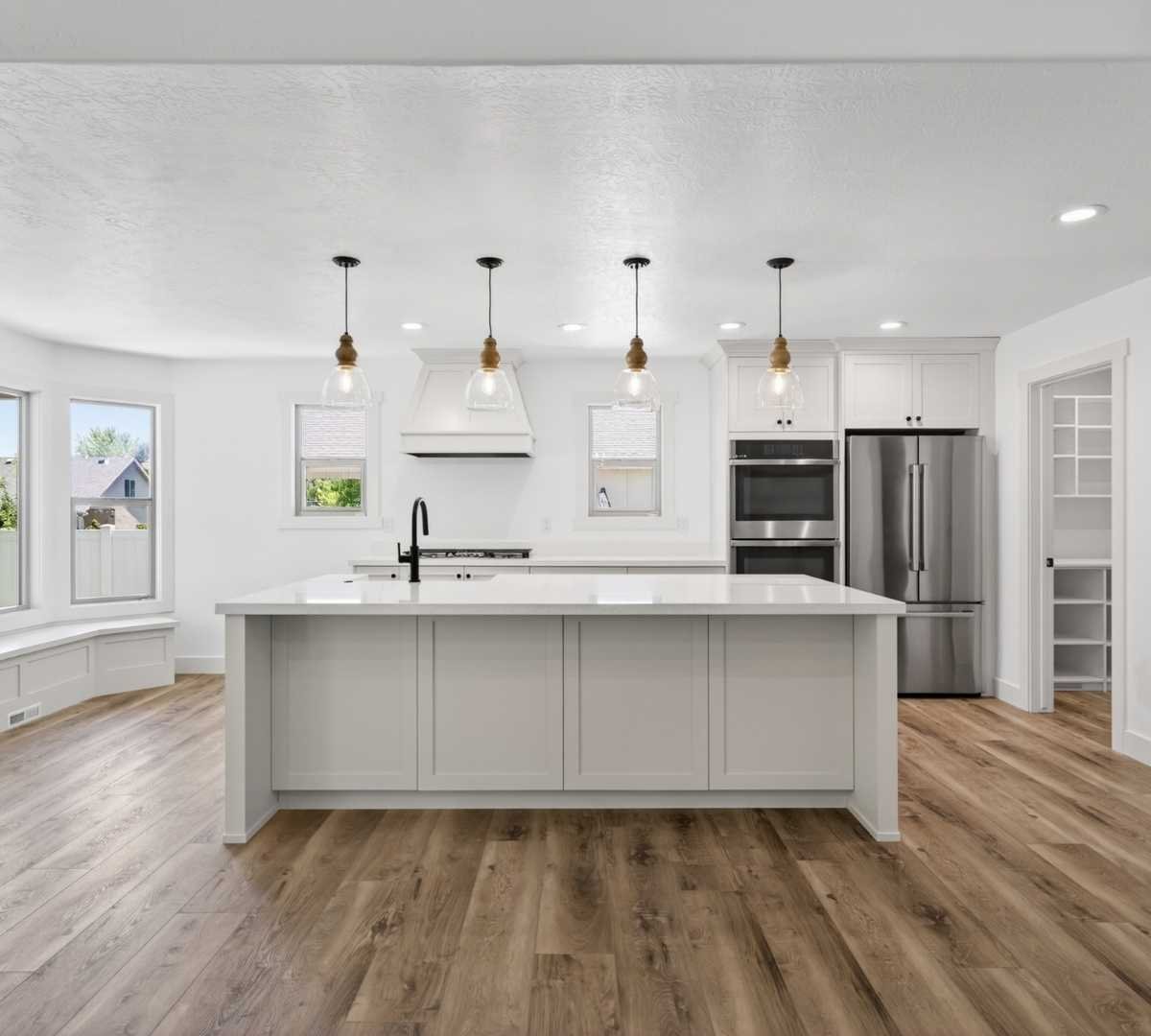 Photo of kitchen remodel with oversized island and custom cabinetry by Marshall Homes in Herriman, UT
