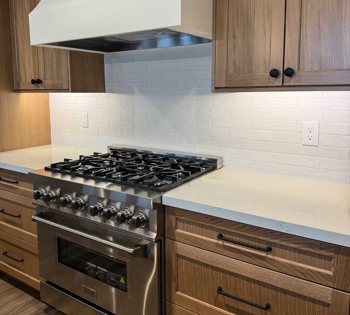 View of a gas range and cabinets in a kitchen remodel by Marshall Homes Utah in Salt Lake City