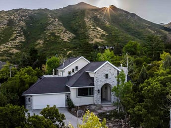 Image of whole home remodel with updated exterior, hillside location, and surrounding trees in Olympus Cove, UT by Marshall Homes