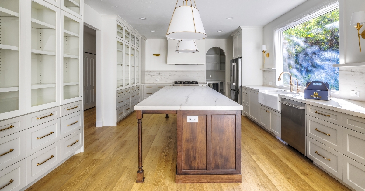 Kitchen with white and glass cabinetry, gold handles and faucet, and wood features by Marshall Homes in Utah
